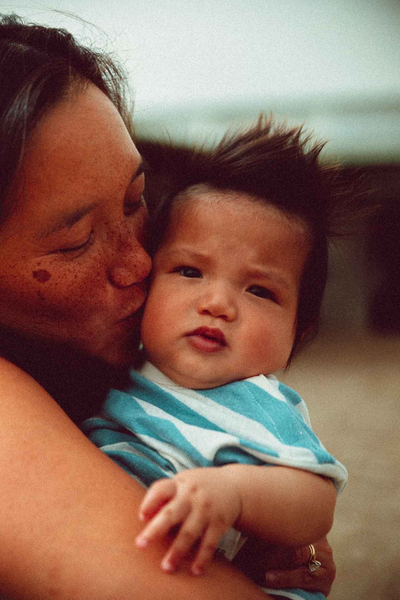 Mère embrassant son enfant – photoreportage de famille en Corse